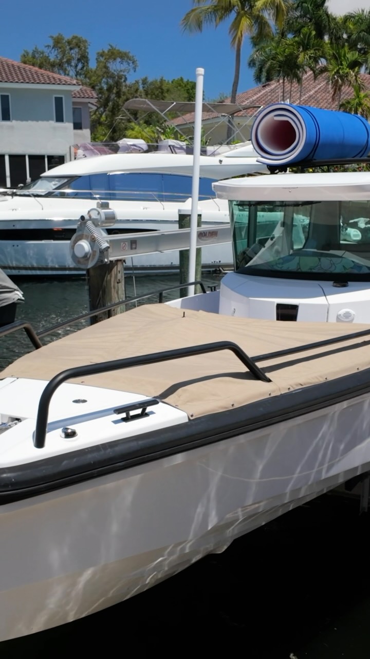 Fitted tan bow cover following the forward seating area and black rails on an Axopar 28